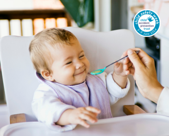 child in a highchair being fed